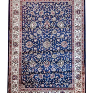 Handcrafted luxury wool rug ‘Nawab’s Garden,’ made in India, featuring intricate sapphire-blue and ivory floral vines with ruby-red accents.