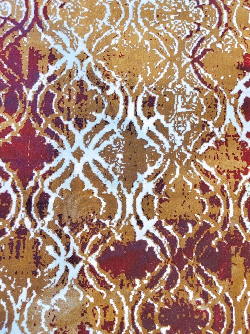 A close-up of the Autumn Horizon Rug showcasing its plush texture and vibrant red, white, and beige patterns against a blurred background. Handmade and available in Mumbai, India.