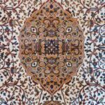 A close-up of the Golden Minaret Rug featuring intricate floral patterns in red, blue, and beige, with a plush texture. Handmade and available in Mumbai, Thane, India.