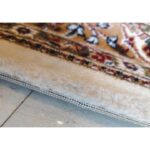 A section of the Golden Minaret Rug with a central medallion, floral motifs, and vibrant colors like brown, beige, and green, highlighting its intricate craftsmanship.