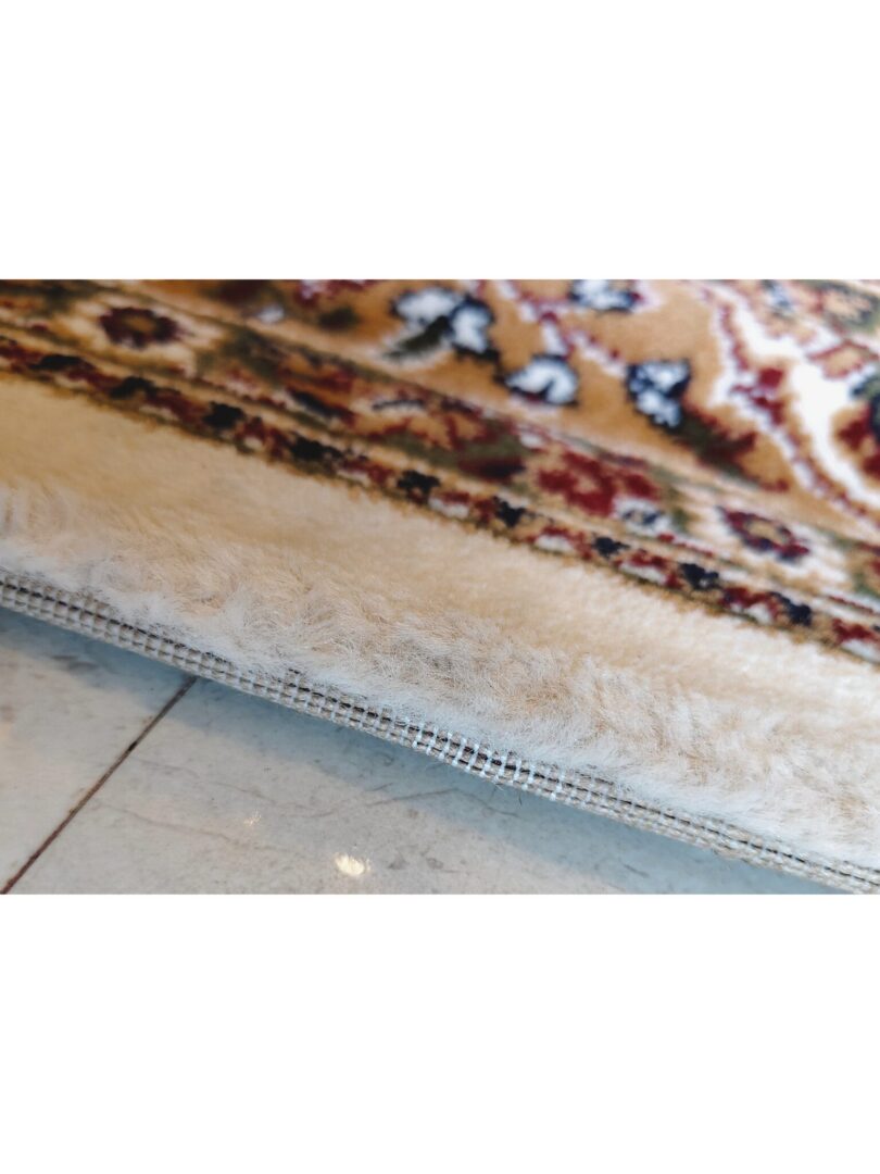 A section of the Golden Minaret Rug with a central medallion, floral motifs, and vibrant colors like brown, beige, and green, highlighting its intricate craftsmanship.