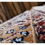 A detailed view of the Golden Minaret Rug with ornate floral and abstract patterns in red, green, and beige, showcasing its plush texture.
