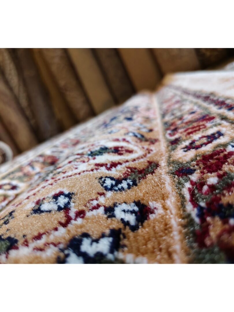 A detailed view of the Golden Minaret Rug with ornate floral and abstract patterns in red, green, and beige, showcasing its plush texture.