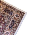 The Golden Minaret Rug features a traditional Persian design with floral and geometric patterns in muted tones, paired with a visible label for quality assurance.