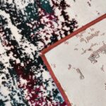 A close-up of the Jingle Frost Rug featuring plush abstract patterns in white, red, and black, with a red