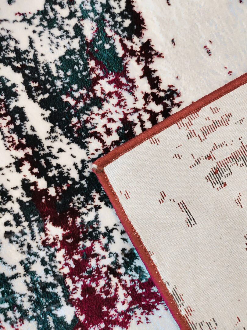 A close-up of the Jingle Frost Rug featuring plush abstract patterns in white, red, and black, with a red