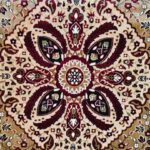 A Zoom section of the Olive Dynasty Rug with a central medallion, floral motifs, and vibrant colors like red, cream, and gold, highlighting its intricate craftsmanship.