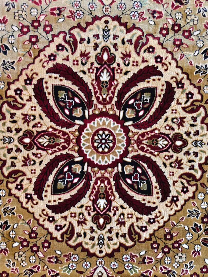 A Zoom section of the Olive Dynasty Rug with a central medallion, floral motifs, and vibrant colors like red, cream, and gold, highlighting its intricate craftsmanship.