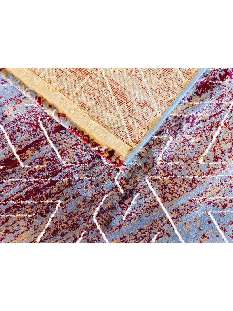 Experience the X Dime Abstract Rug, a modern geometric design with bold white zigzag patterns on a textured background of brown, blue-gray, and burgundy. A handmade wool rug .