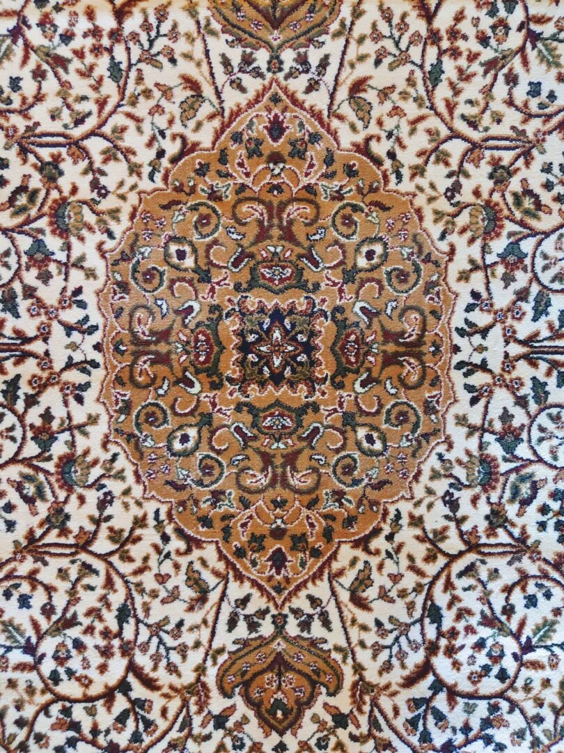 A close-up of the Golden Minaret Rug featuring intricate floral patterns in red, blue, and beige, with a plush texture. Handmade and available in Mumbai, Thane, India.